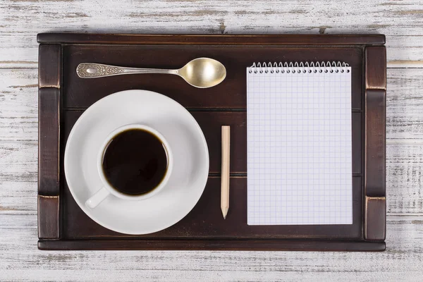 Coffee cup with note book on a tray on white wooden table. Lifestyle concept. Close up, top view — Stock Photo, Image