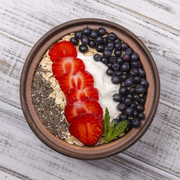 Muesli gemaakt van rode aardbeien, bosbessen, chia zaden, Haver vlokken met yoghurt — Stockfoto