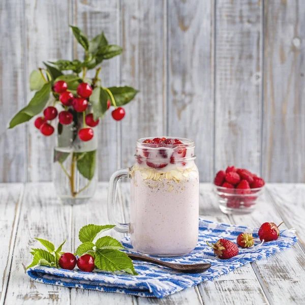 Batidos de fresas, frambuesas, cereza, copos de avena y helado en jarra de albañil —  Fotos de Stock