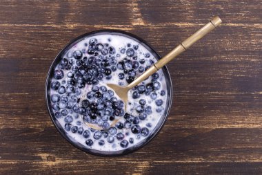 Taze, olgun orman yaban mersini ekşi krema ve ballı siyah plaka.