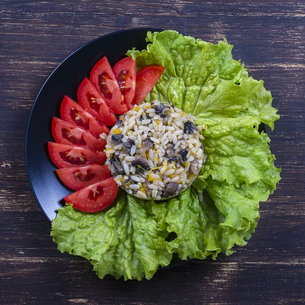 Arroz con setas y hojas de lechuga verde sobre fondo rústico de mesa — Foto de Stock