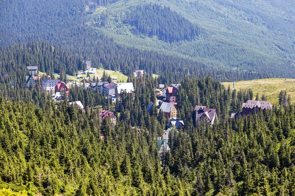 Os abetos verdes e as casas da aldeia Dragobrat contra o contexto das montanhas dos Cárpatos no verão. Ucrânia — Fotografia de Stock