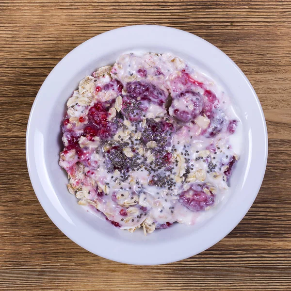 Muesli feito de framboesa, flocos de aveia, sementes de chia com iogurte e mel, close-up — Fotografia de Stock