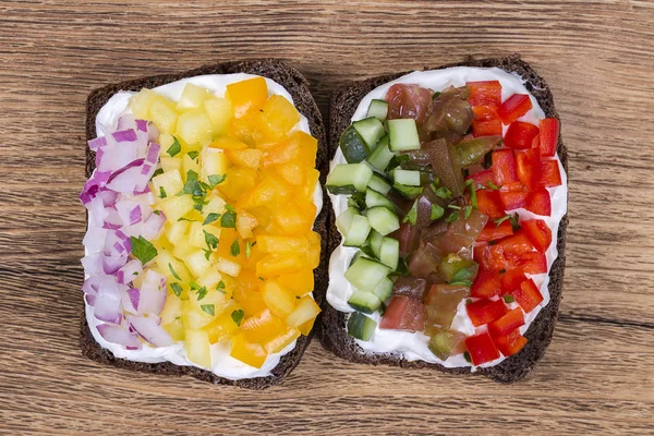 Färgglada grönsaker sandwich, närbild. Färsk paprika, tomater, gurka, lök och ost på svart bröd. Ovanifrån — Stockfoto