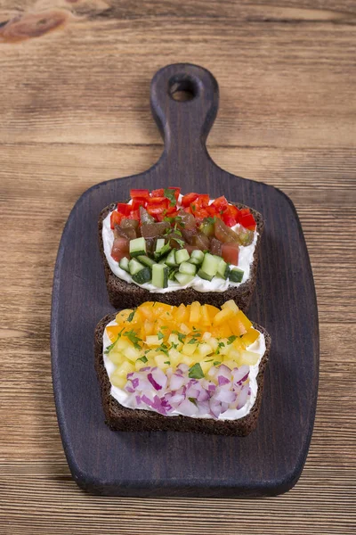 Barevné zeleniny sendvič, zblízka. Čerstvé papriky, rajčata, okurky, cibuli a sýr na černý chléb. Pohled shora — Stock fotografie