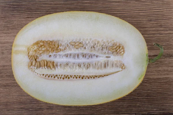 Metade do melão no fundo de madeira, vista superior — Fotografia de Stock