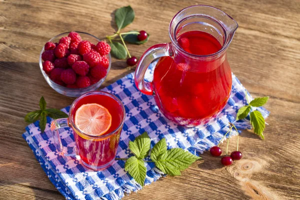 Dietary detox drink med citronsaft, röda jordgubbar, körsbär och hallon i klart vatten med is — Stockfoto