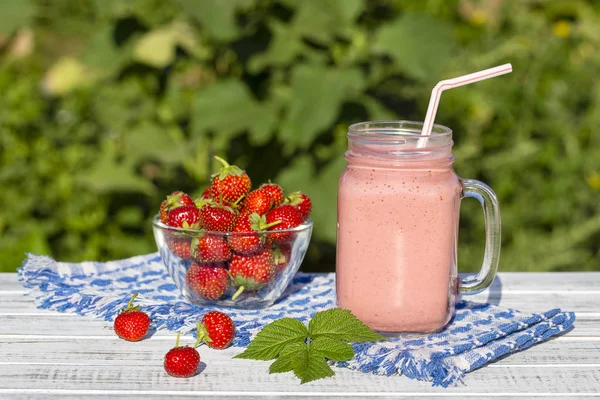 Strawberry, raspberries and banana juice smoothie shake in glass, outdoors, close up — Stock Photo, Image