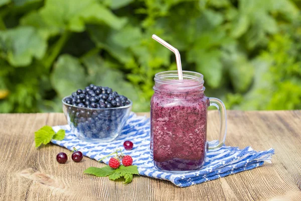 Health smoothie from blueberry, raspberry, cherry and banana in glass mug — Stock Photo, Image