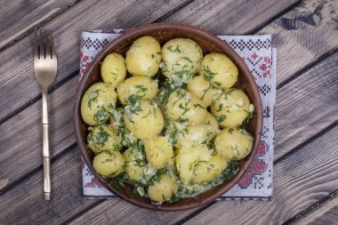 Dereotu, sarımsak ve ahşap masa, üstten görünüm tabağa tereyağı haşlanmış patates