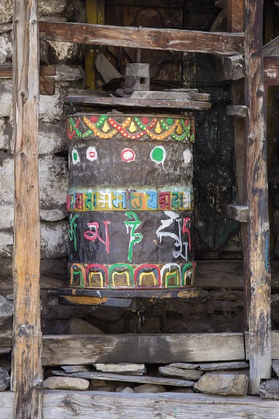 Буддийские молитвенные колеса в тибетском монастыре с письменной мантрой. Гималайская деревня — стоковое фото