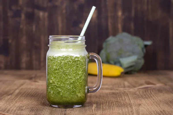 Cam bardak suyu smoothie shake dereotu, brokoli, ahşap arka plan, muz yakın çekim