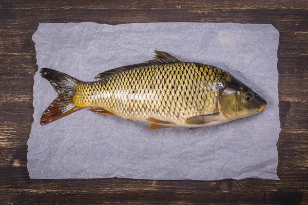 Common carp fish on wooden background, close up — Stock Image Common carp fish on wooden background, close up Stock Picture
