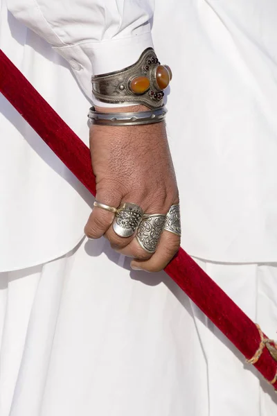 Belle mani uomo decorate con anelli tiene una sciabola al Desert Festival a Jaisalmer, India. Da vicino. — Foto Stock