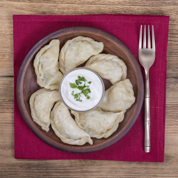 Ukrainian and Russian dishes - vareniki or dumplings with mashed potatoes or cottage cheese, sour cream and parsley, close up — Stock Photo, Image