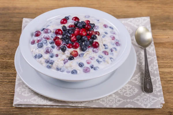 Müsli gjord av blåbär, tranbär, havregryn med yoghurt och honung, närbild — Stockfoto