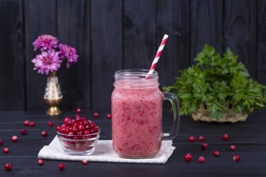 Kızılcık suyu smoothie shake cam kupa ve siyah ahşap arka plan üzerinde ham kızılcık yakın çekim