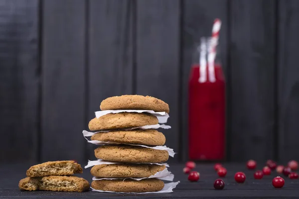 Havreflarn, tranbärsjuice och rå tranbär på svart trä bakgrund, närbild — Stockfoto