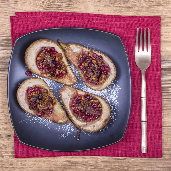 Hausgemachte gebackene Birnen mit Honig, roten Preiselbeeren und Walnüssen aus nächster Nähe — Stockfoto