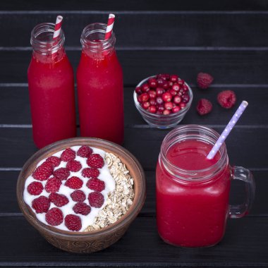 Ahududu suyu bir bardak kupa ve ham ahududu, yoğurt ve siyah ahşap arka plan, ballı yulaf gevreği yapılan müsli yakın çekim