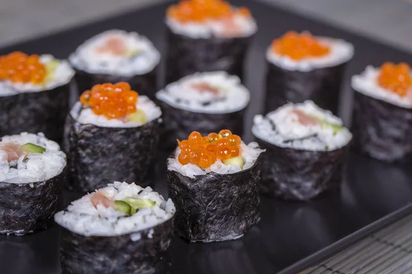 Rollo de sushi con salmón, pepino, aguacate, caviar rojo. Menú de sushi. Comida japonesa. De cerca. — Foto de Stock
