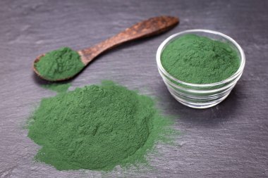 Organik spirulina yosun toz siyah arduvaz plakalı arka plan üzerinde