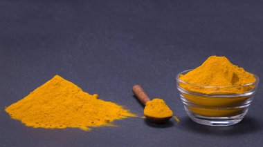 Organik zerdeçal, curcuma toz siyah arduvaz plakalı arka plan üzerinde. Köri tozu