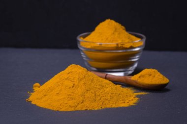 Organik zerdeçal, curcuma toz siyah arduvaz plakalı arka plan üzerinde. Köri tozu