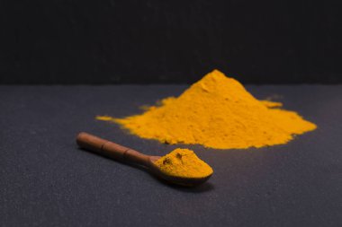 Organik zerdeçal, curcuma toz siyah arduvaz plakalı arka plan üzerinde. Köri tozu