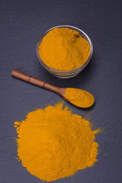 Organik zerdeçal, curcuma toz siyah arduvaz plakalı arka plan üzerinde. Köri tozu