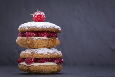 Yulaf kurabiye ham ahududu, bal ve siyah arduvaz arka plan üzerinde yumuşak peynir ile yakın çekim