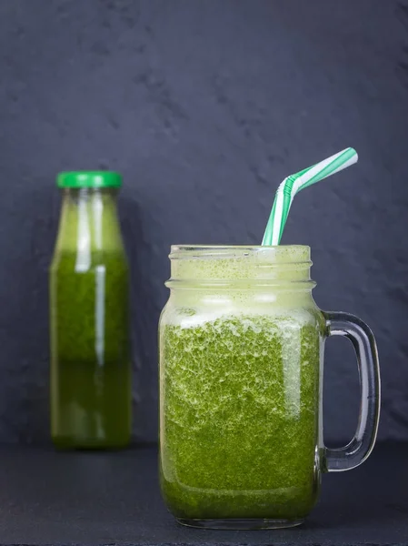 Glas mugg av juice smoothie skaka från persilja, äpple, broccoli, banan på svart skiffer bakgrund, närbild — Stockfoto