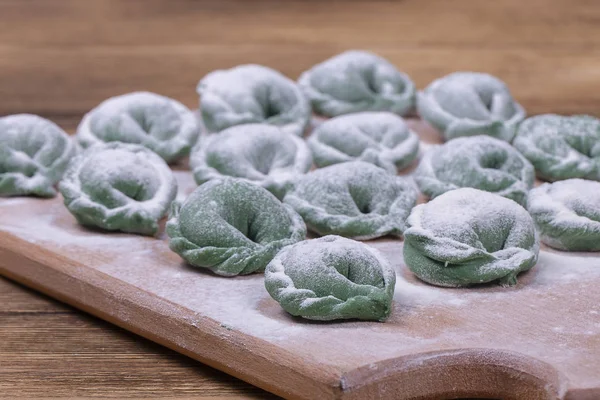 Vihreä raaka pelmeni spirulinalla. Ukrainan ja Venäjän ruokia - vareniki tai nyytit naudanlihaa tai perunamuusia tai raejuustoa — kuvapankkivalokuva