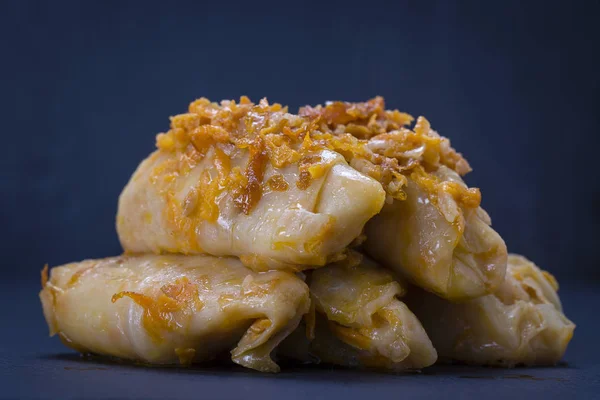 Rollos de col rellenos caseros con arroz y carne en salsa de tomate sobre un fondo de pizarra negra, de cerca —  Fotos de Stock