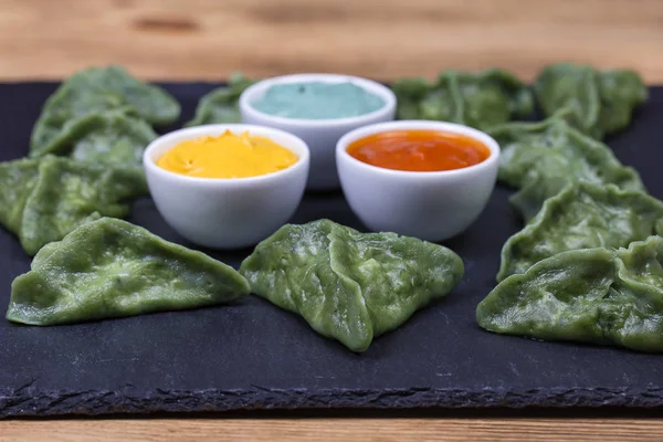 Green dim sum, chinesisches Essen. Knödel mit Rindfleisch oder Kartoffelpüree oder Quark im Teig mit Spirulina — Stockfoto