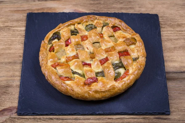 Homemade organic chicken pie with vegetables to eat on the black slate — Stock Photo, Image