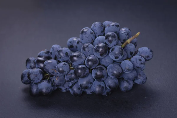 Único ramo uvas azuis no fundo ardósia pedra preta — Fotografia de Stock