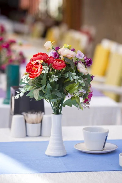 Boeket van kunstbloemen is ingericht op de tafel in een café in de buurt van het strand. Kemer, Turkije — Stockfoto