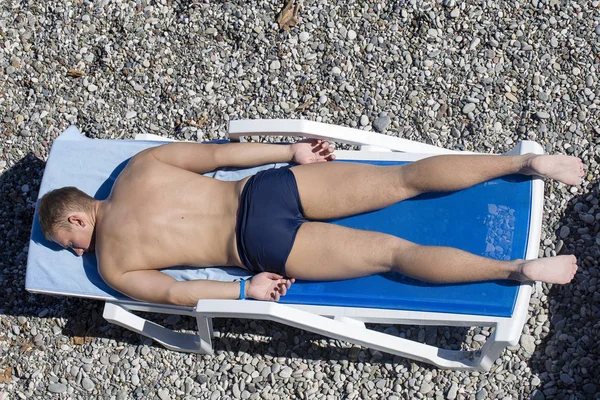 Un uomo che prende il sole su una spiaggia di ghiaia. Kemer, Turchia — Foto Stock