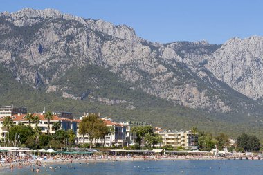 İnsanlar zevk Güneş ve deniz turkuaz deniz ve çakıl Plajı'nda. Kemer, Türkiye