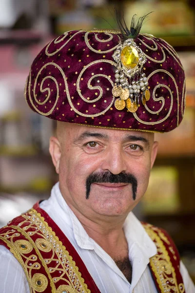 Retrato de un hombre turco vestido con ropa nacional, que vende dulces orientales en un bazar local en Kemer, Turquía —  Fotos de Stock