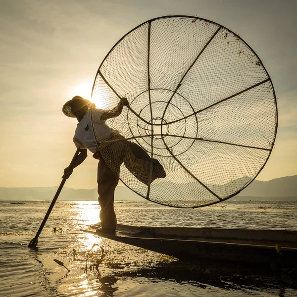 Burmese fisherman on bamboo boat catching fish in traditional way with handmade net. Inle lake, Myanmar, Burma — Stock Photo, Image