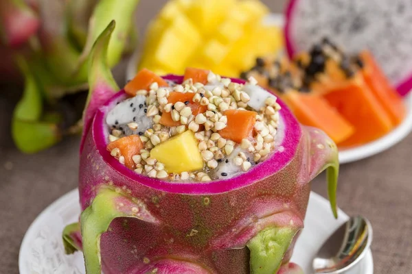Fresh tropical fruit salad with green buckwheat and honey in dragon fruit skin, close up — Stock Photo, Image