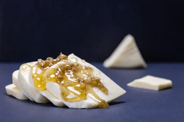 Suluguni-Käse, Walnuss und Honig auf schwarzer Schieferplatte — Stockfoto
