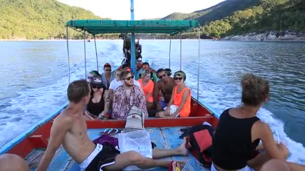 Люди, сидящие в лодке, путешествуют в морской воде на острове Ко Панган, Сурат Тани, Таиланд . — стоковое видео