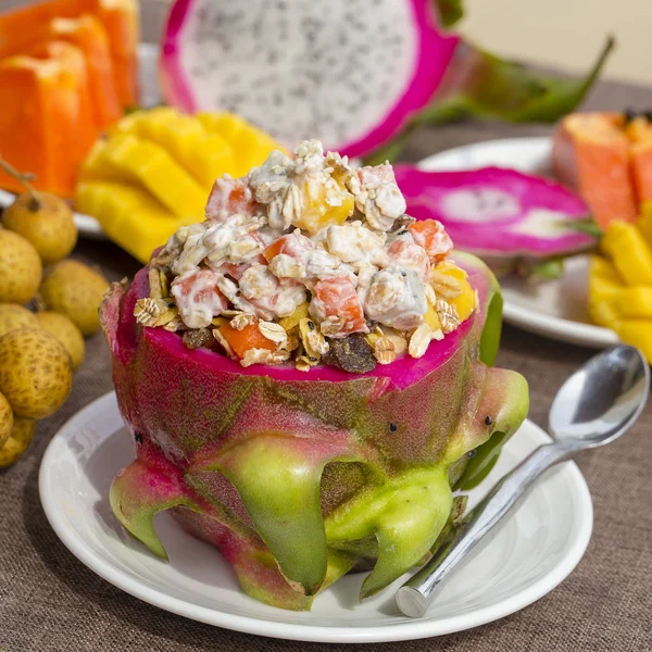 Verse tropische fruitsalade met Haver vlokken, rozijnen, noten, yoghurt en honing in dragon fruit huid, close-up — Stockfoto