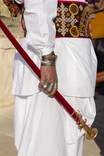 在印度拉贾斯坦邦斋的沙漠节上, 用戒指装饰的漂亮男人手中握有一把军刀。. — 图库照片