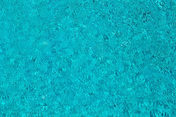 Wasser plätschert auf blau gefliestem Schwimmbadhintergrund. Ansicht von oben. — Stockfoto