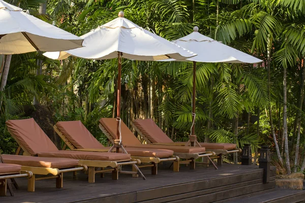 Plážová lehátka a slunečníky na pláži u moře v tropickém hotel, Thajsko — Stock fotografie