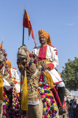Geleneksel Rajasthani elbise giyen deve ve Hint erkek Jaisalmer, Rajasthan, Hindistan çöl Festivali olarak Bay Desert yarışmaya katılmak